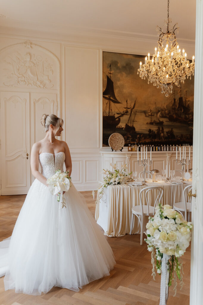 Braut in einem eleganten Hochzeitssaal im Weissenhaus Private Nature Luxury Resort während eines Fine Art Styled Shoots.